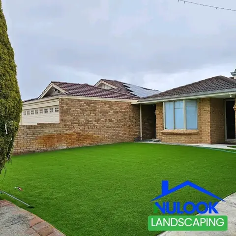 Brick house seen from another angle, with artificial grass covering the front yard